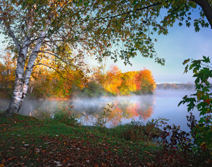 USA, Maine, Pittsfield. Morning sun and fog rising from Douglas Pond. 