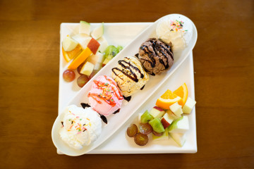 Five scoops of ice cream placed in a long plate placed on the table