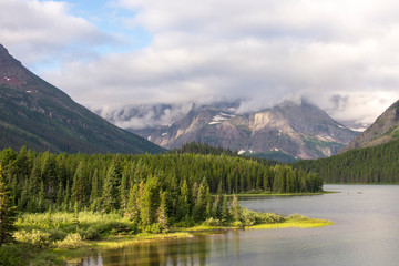 USA, Montana, Glacier National Park. Morning light on Swiftcurrent Lake with peaks cloud covered.