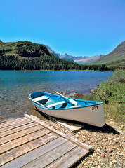 Fototapeta na wymiar USA, Montana, Glacier NP. A canoe awaits its next adventurers at Swiftcurrent Lake, Glacier NP, Montana.