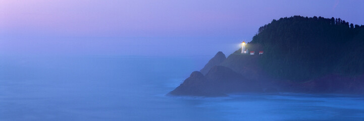 USA, Oregon, Heceta Head. The beacon of Heceta Head Lighthouse shines through the periwinkle blue...