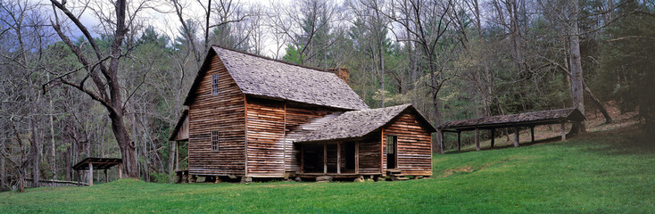 USA, Tennessee, Great Smoky Mts NP. A wooden house sits nestled in the green of Cades Cove, a World...