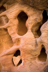 USA, Utah, Canyonlands National Park. Heart-shaped rock wedged in opening of sandstone formation. 