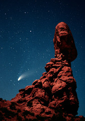 Fototapeta na wymiar USA, Utah, Arches National Park. Comet Hale-Bopp streaks across the night sky past Balanced Rock, which is lit by a half-moon. 