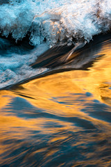 Fototapeta na wymiar USA, Utah. Abstract design of ice and canyon wall reflections on ice lined Mill Creek near Moab
