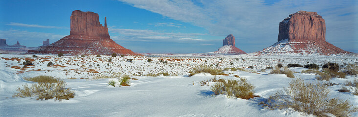 USA, Utah, Monument Valley. Sagebrush shows through the snow in front of Merrick Butte and the Mittens in Monument Valley, a Navajo Tribal Park, Utah.