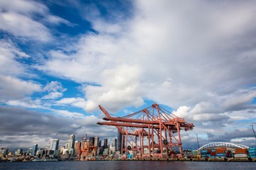 USA, Washington State, Seattle. Large cranes at the Port of Seattle, with the city skyline in the...