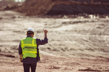 Portrait of back asian male supervisor walking in mine soil field location background
