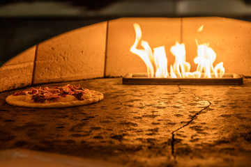 Pizza cooking in gas fired brick fired oven in Spokane, Washington State, USA