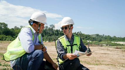 portrait of two engineer's or architect's dress with hardhat, safety helmet and safety vest have a meeting outdoors