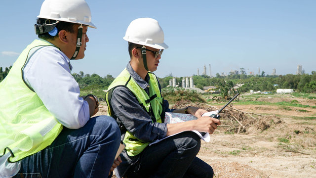 portrait of two engineer's or architect's dress with hardhat, safety helmet and safety vest have a meeting outdoors
