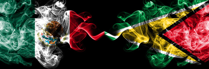 Mexico vs Guyana, Guyanese smoky mystic flags placed side by side. Thick colored silky abstract smokes banner of Mexican and Guyana, Guyanese