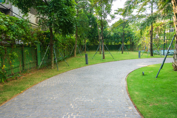 Urban walking road among green trees inside modern apartment building area in big city