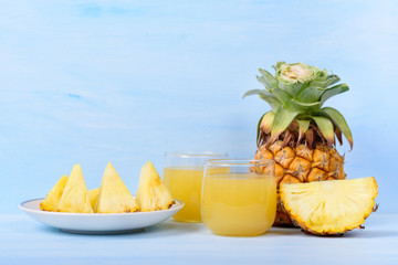 Obraz na płótnie Canvas Pineapple juice in glass and sliced pineapple fruit, tropical drink