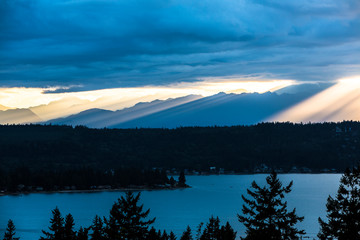Bremerton, Washington State. Rays of sunshine rain down over the Olympic Mountains and the Puget...