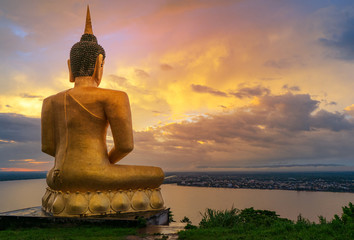 The big golden Buddha statue of Phu Salao temple with Mekong River flows through the Pakse city in...