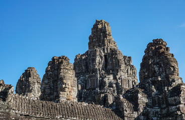 Detail Mural faces in the stone of Bayon belong angkor thom nearly angkor wat is popularity of the site among tourists with blue sky in background. UNESCO World Heritage Site. Siem Reap, Cambodia