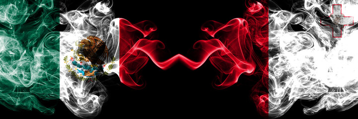 Fototapeta premium Mexico vs Malta, Maltese smoky mystic flags placed side by side. Thick colored silky abstract smokes banner of Mexican and Malta, Maltese