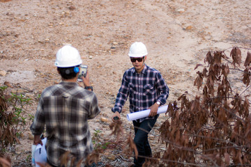 Naklejka premium portrait of two engineer's or architect's dress with hardhat, safety helmet have a taking selfie white cell phone