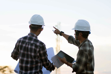 portrait of two engineer's or architect's dress with hardhat, safety helmet meeting outdoors at...