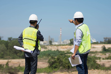 portrait of two engineer's or architect's dress with hardhat safety helmet and safety vest have a...