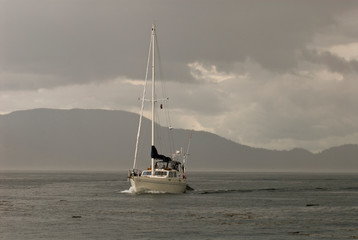 USA, WA, San Juan Islands. Sailboat motors out of squall