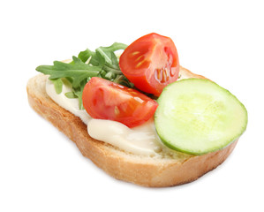 Slice of bread with spread and vegetables on white background