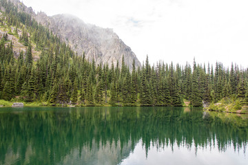 Fototapeta na wymiar USA, Washington State, Olympic National Forest. Silver Lake in Buckhorn Wilderness. Meditative reflection on flat calm lake