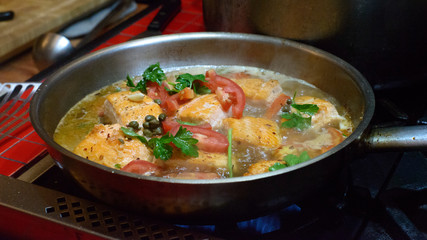 Cooked salmon dish in frying pan.