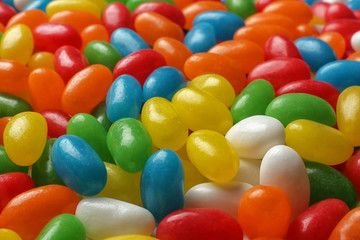 Fototapeta na wymiar Tasty bright jelly beans as background, closeup