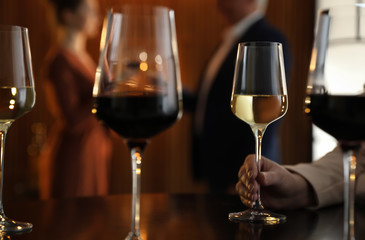 Woman with glass of wine in restaurant, closeup