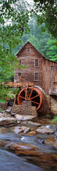 USA, West Virginia, Babcock SP. The vertical format enhances the aging structures of Glade Creek Grist Mill, in West Virginia's Babcock State Park