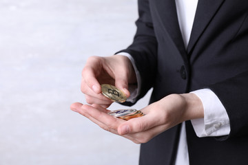 Person holding bitcoins on light background, closeup. Space for text