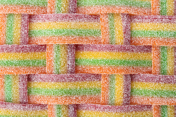 Plaited delicious jelly candies as background, top view