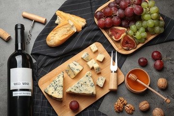 FLat lay composition with board of delicious blue cheese and wine on stone background