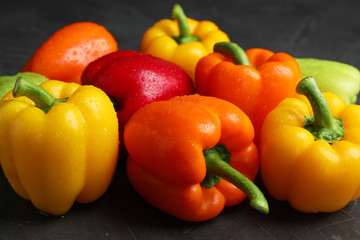 Wet ripe bell peppers on grey table
