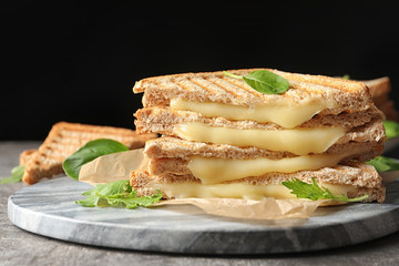 Marble board with fresh cheese sandwiches on table