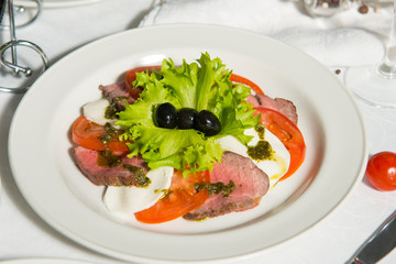A restaurant dish of chopped smoked meat on a table in a plate. Cold appetizer.