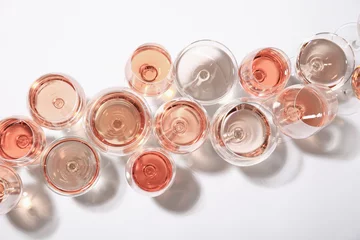 Schilderijen op glas Different glasses with rose wine on white background, top view © New Africa