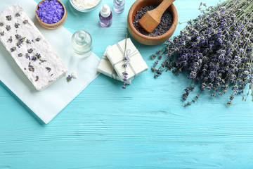 Obraz na płótnie Canvas Flat lay composition with hand made soap bars and lavender flowers on light blue wooden table, space for text