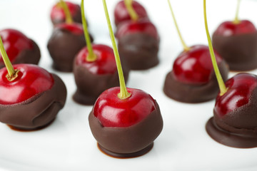 Chocolate dipped cherries on white background, closeup