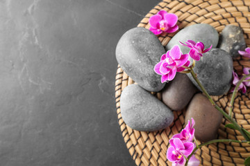 Naklejka na ściany i meble Flat lay composition with orchid flowers and spa stones on grey table. Space for text