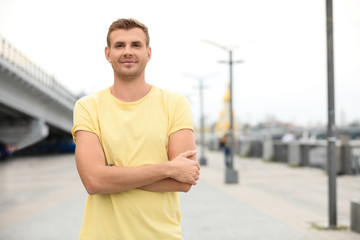 Fototapeta premium Portrait of handsome man with crossed arms in city