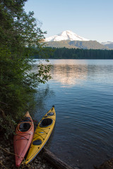 USA, Washington State. Kayaks tethered at edge of Baker Lake with Mt. Baker reflected in calm...