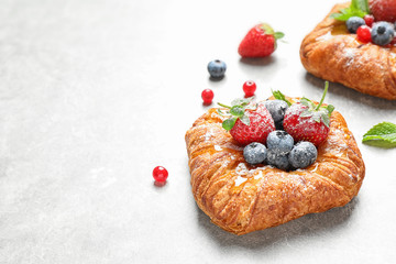 Fresh delicious puff pastry with sweet berries on light background. Space for text