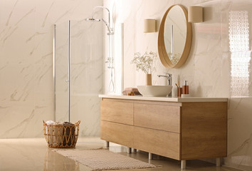 Modern bathroom interior with stylish mirror, vessel sink and glass shower stall