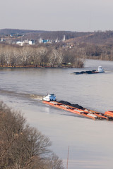 US, West Virginia, Parkersburg. Coal barges navigate up Ohio River seen from historic Fort Boreman Park. Blennerhassett Island in river is historical state park