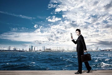 Asian businessman holding a briefcase.