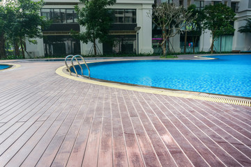Blue swimming pool with wood flooring stripes