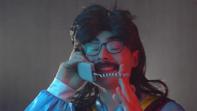 Man with mustache and mullet from the 70s 80s 90 talking on the phone. Vintage concept.